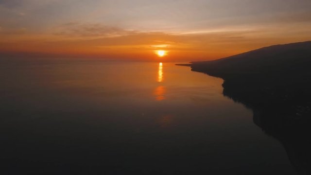 Sea coast at sunset. Aerial view of sunset on the ocean coast, sea, beach, sky, clouds. Bali, Indonesia. Sunset on the island of Bali. 4K, Aerial footage