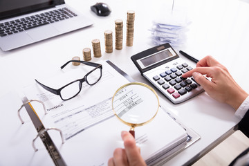 Businesswoman Checking Invoice With Magnifying Glass