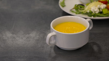 Squash soup on kitchen table.  Copy space.