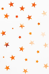 Holiday background with orange star confetti. Good background for Christmas and New Year cards.