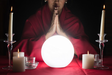 Fortuneteller With Clasped Hands And A Glowing Crystal Ball