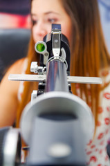Fototapeta na wymiar Unidentified woman checks vision by modern equipment, eyes exam in optical, in a blurred background