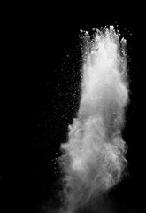 Freeze motion of white powder explosions isolated on black background.