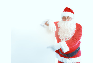 Happy Santa Claus looking out from behind the blank sign isolated on white background