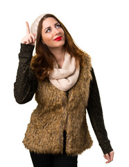 Girl with winter clothes pointing up