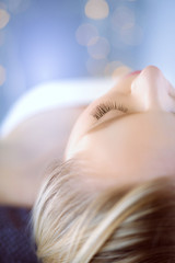 Fototapeta premium Young woman lying on a massage table,relaxing with eyes closed. Woman. Spa salon