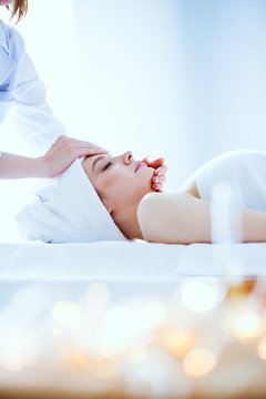Young woman lying on a massage table,relaxing with eyes closed. Woman. Spa salon