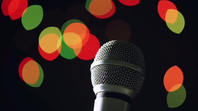 Audio microphone in karaoke bar with festive bokeh light background