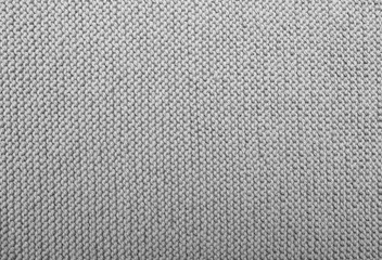 Gray knitted fabric texture. Hand knitting. Face side Interlacing of threads close up. Detailed warm yarn background.