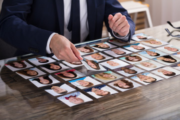 Businessperson Choosing Photograph Of Candidate