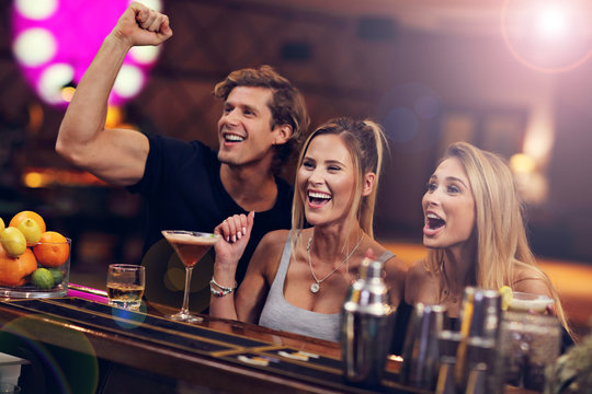 Group Of Friends Enjoying Drink in Bar