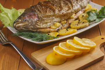 Baked salmon in the oven. View from above. The fish is decorated with greenery. Ready to use.