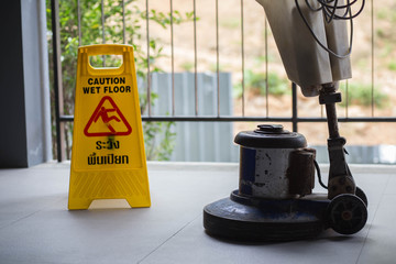 The people cleaning floor with machine.