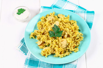 Indian biryani with chicken, yogurt and spices in a plate on a wooden table. New Year's, Christmas dish.