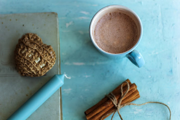 top view cocoa cup old book cinnamon sticks and knitted heart