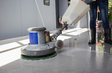 The people cleaning floor with machine.