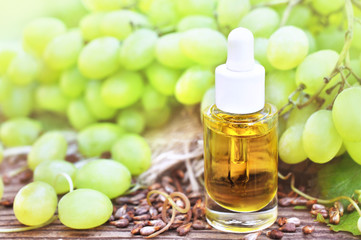 Essential oil on green grape fruits and stones background, selective focus