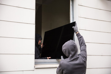 Robbers Stealing Television Through House Window