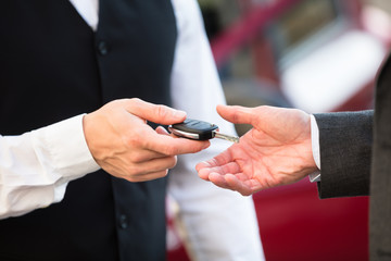Fototapeta na wymiar Valet Giving Car Key To Businessperson