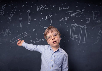 Little boy in front of a drawn up blackboard