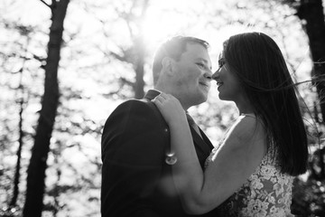 Young bride and groom walking high in mountains. Amazing weather with fog and sun