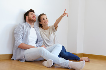 happy couple at empty room of new home