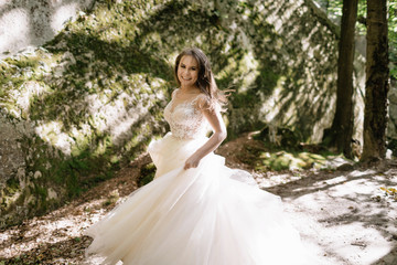 Fototapeta na wymiar Beautiful stylish bride walking in the forest