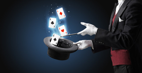 Magician making trick with wand and playing cards