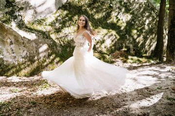 Beautiful stylish bride walking in the forest