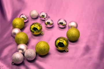 the heart is lined with Christmas balls on pink background
