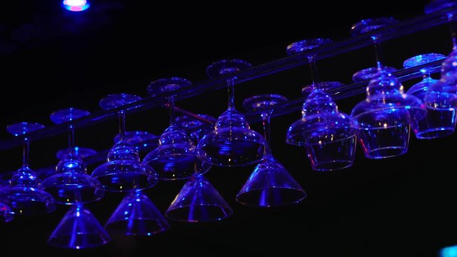 Cocktail glasses hanging over a bar at a nightclub