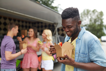 happy man with wok and friends at food truck