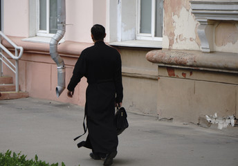Priest praying to God. Handsome young catholic priest read the Bible
