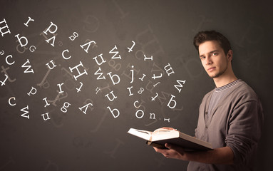 Young man holding book with letters