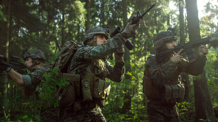 Fully Equipped Soldiers Wearing Camouflage Uniform Attacking Enemy, Rifles in Firing Position. Military Operation in Action, Squad Running in Formation Through Dense Forest. Side View Long Shot.