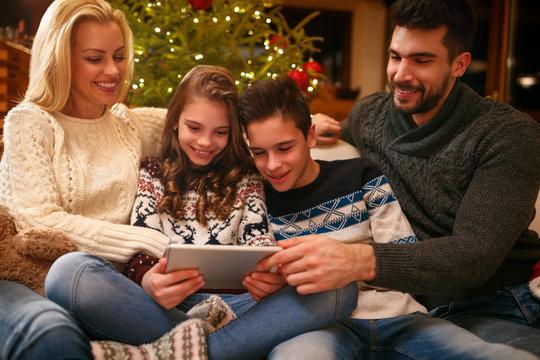 Family on Christmas holiday looking photos on tablet