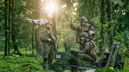 In the Military Staging Base Army Engineer and Soldiers Operate Military Grade Industrial Drone for their Reconnaisance/ Surveillance Mission/ Operation. Theater of Operation is in Forest Area.