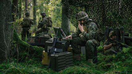Military Staging Area, Chief Engineer Uses Radio and Army Grade Laptop. Forest Operation/ Mission in Progress.