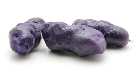 Boiled vitelotte potatoes isolated on white background three peeled purple.