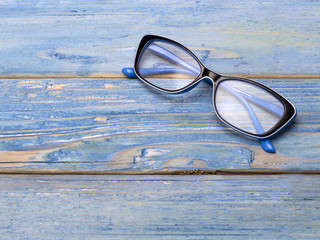 glasses for sight on a blue wooden background. 