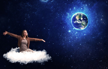 Woman sitting on cloud looking at planet earth