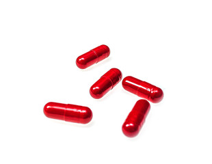 Red capsules pills on white background