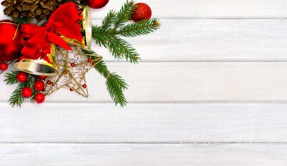 Christmas decoration with christmas bells, branch of christmas tree, red berries, cone pine, star and red balls on background of white painted wooden planks with space for text. Top view, flat lay