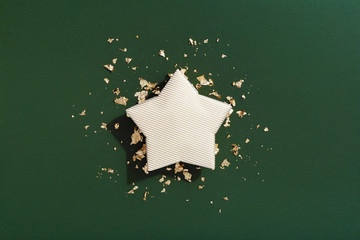 Star shaped Christmas gift flat lay, gold and dark green background