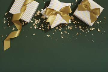 Christmas gift flat lay, gold and dark green background