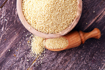 couscous in wooden spoon and couscous wooden bowl.