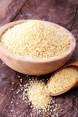 couscous in wooden spoon and couscous wooden bowl.