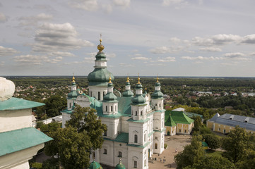 Fototapeta na wymiar Chernigov, Ukraine. August 15, 2017. Christian orthodox white church with green domes and gold crosses. View from high. Calm sky above