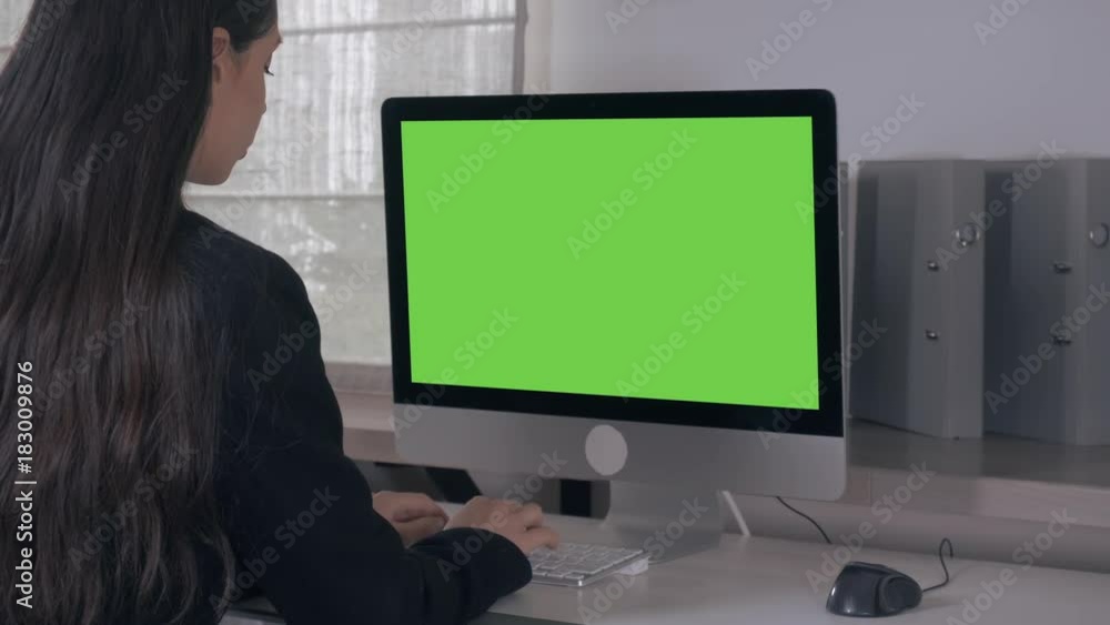 Aufkleber back view woman with long hair sitting in front of display computer with green screen. unrecognizabl