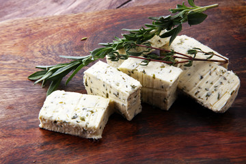 Butter with thyme and rosemary and lemon zest. Sliced on a wooden board with herbs
